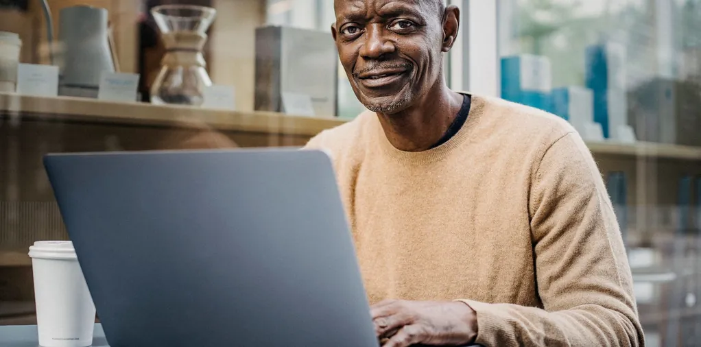 Hombre de mediana edad comparando precios en su portátil